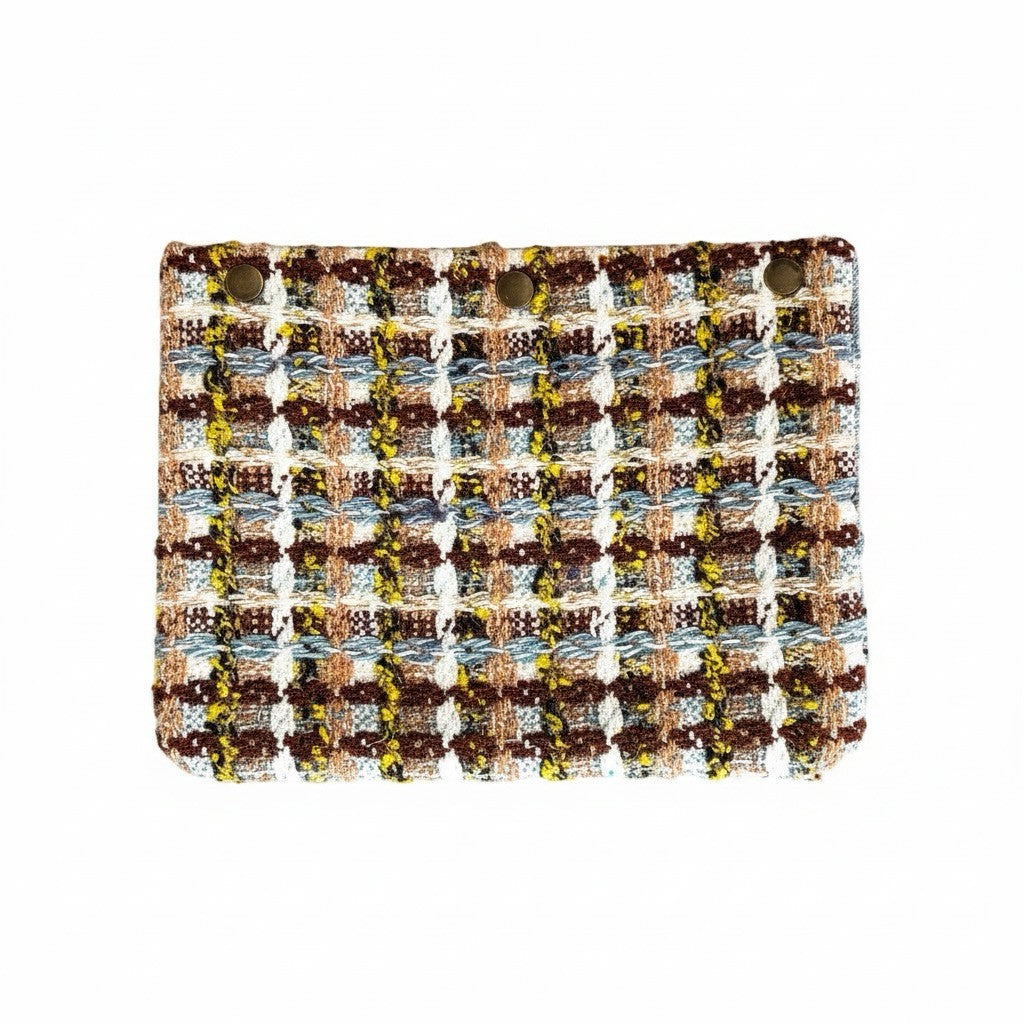 Sac à bandoulière La Stella en tweed texturé carreaux marron, blanc, bleu et jaune, avec chaîne décorative.