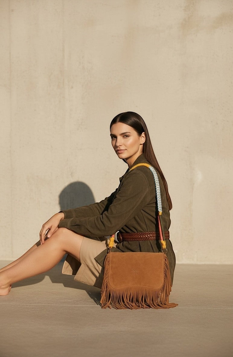 La Stella bandoulière en cuir suédé marron avec franges, ornée d'une sangle multicolore tressée inspirée des cordages marins.